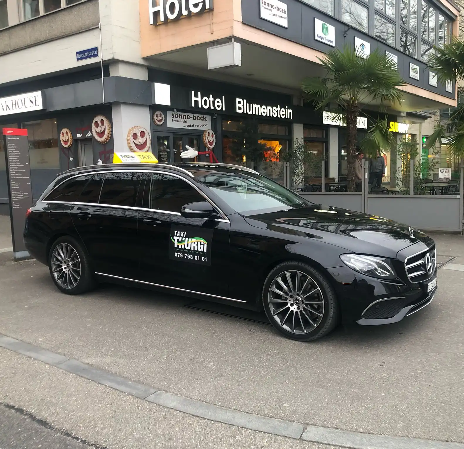 Taxi Thurgi fährt auf malerischer Strasse durch üppige grüne Landschaft.